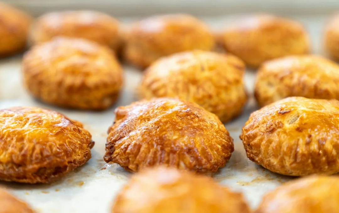 Golden brown baked pastries arranged on a parchment lined baking sheet