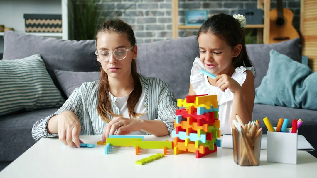 Two girls building with colorful blocks at a table